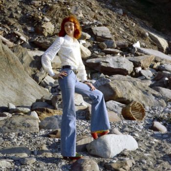 1970s Vintage clothing online- Rehead model in white blouse and bell bottom jeans, Devon, UK, 1970s.