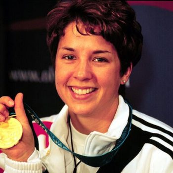 Gold shell suit, Nancy Johnson holding up her gold medal.