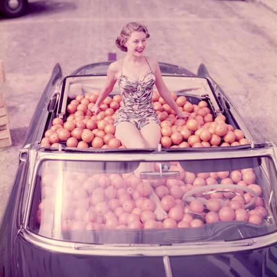 Douglas Jones photograph of a Woman in swimsuit in a car full of oranges, 1951