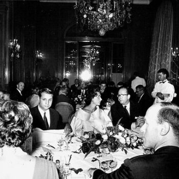 1962 the business of haute couture - Black and white photo of fashion journalist Marie-Jacques Perrier at a dinner for the designer Charles Jourdan, Plaza Athénée hotel in 1962