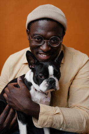 Image of a black male with black and white dog. Used to illustrate article on Edward Enninful's autobiography.