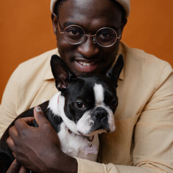 Image of a black male with black and white dog. Used to illustrate article on Edward Enninful's autobiography.