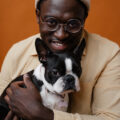 Image of a black male with black and white dog. Used to illustrate article on Edward Enninful's autobiography.